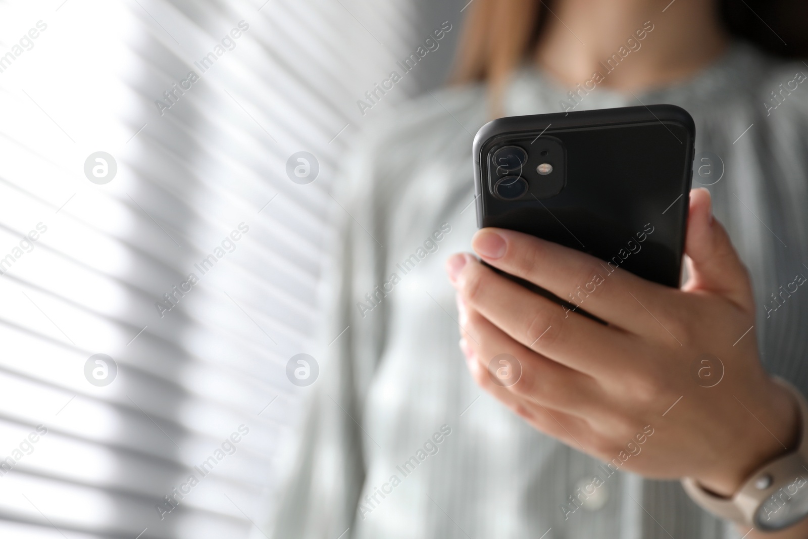 Photo of MYKOLAIV, UKRAINE - MARCH 16, 2020: Woman holding iPhone 11 Black indoors, closeup