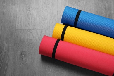 Photo of Bright rolled camping mats on grey wooden background
