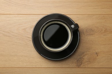 Photo of Hot coffee in cup on wooden table, top view