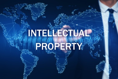 Image of Intellectual property concept. Man using virtual screen with world map illustration, closeup