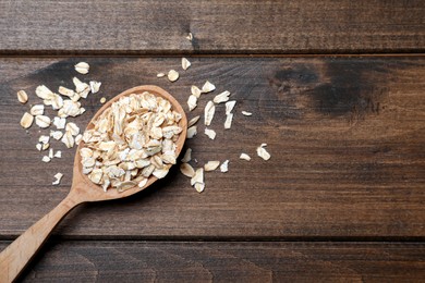 Photo of Spoon with oatmeal on wooden table, flat lay. Space for text