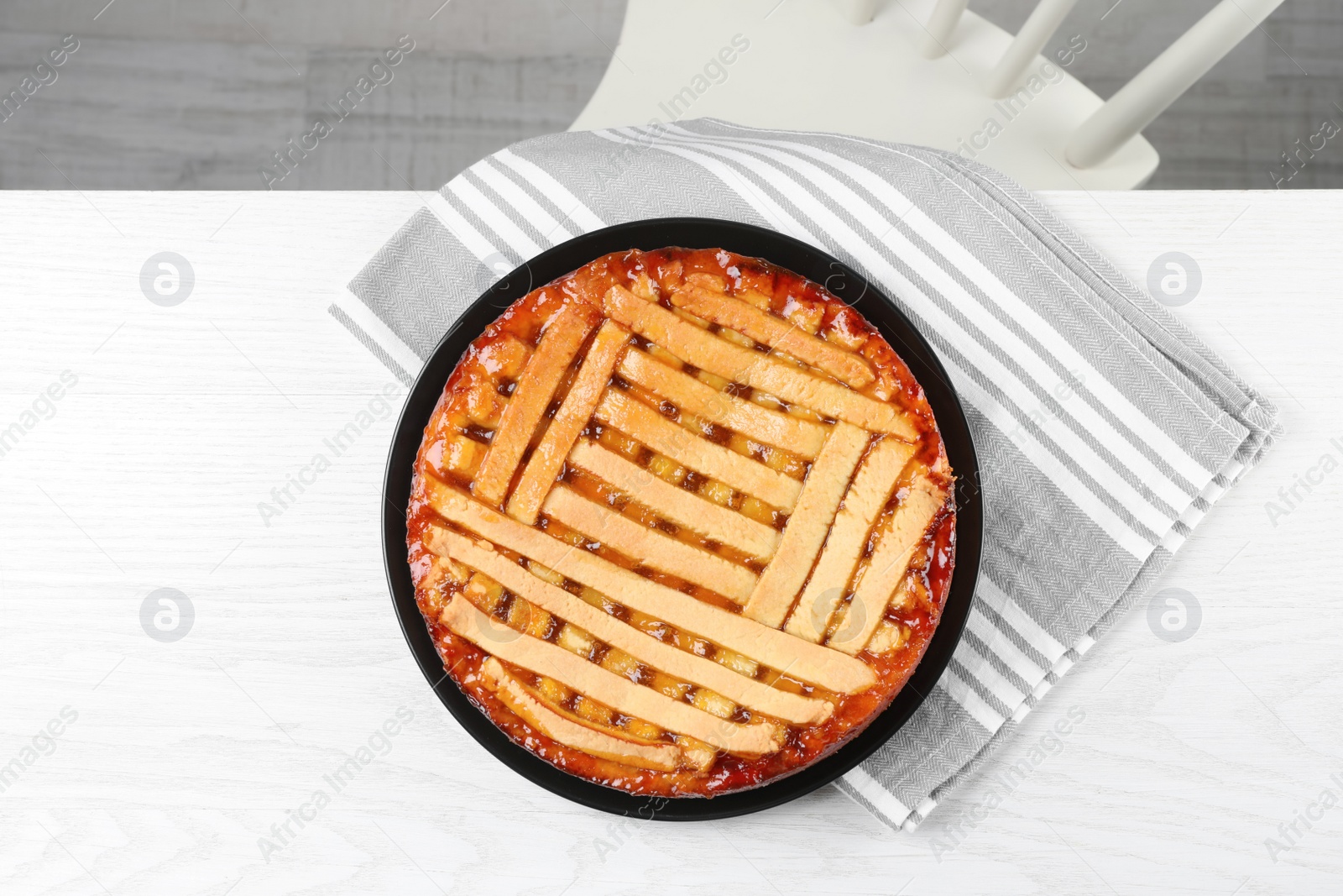 Photo of Tasty apricot pie on white wooden table, top view