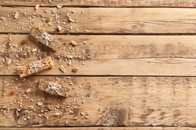 Photo of Different homemade grain cereal bars on wooden table, top view