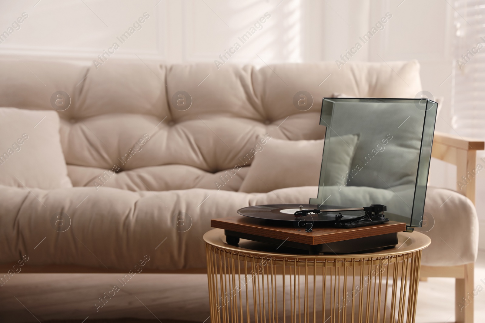 Photo of Stylish turntable with vinyl disc in living room