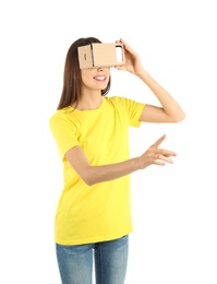 Young woman using cardboard virtual reality headset, isolated on white