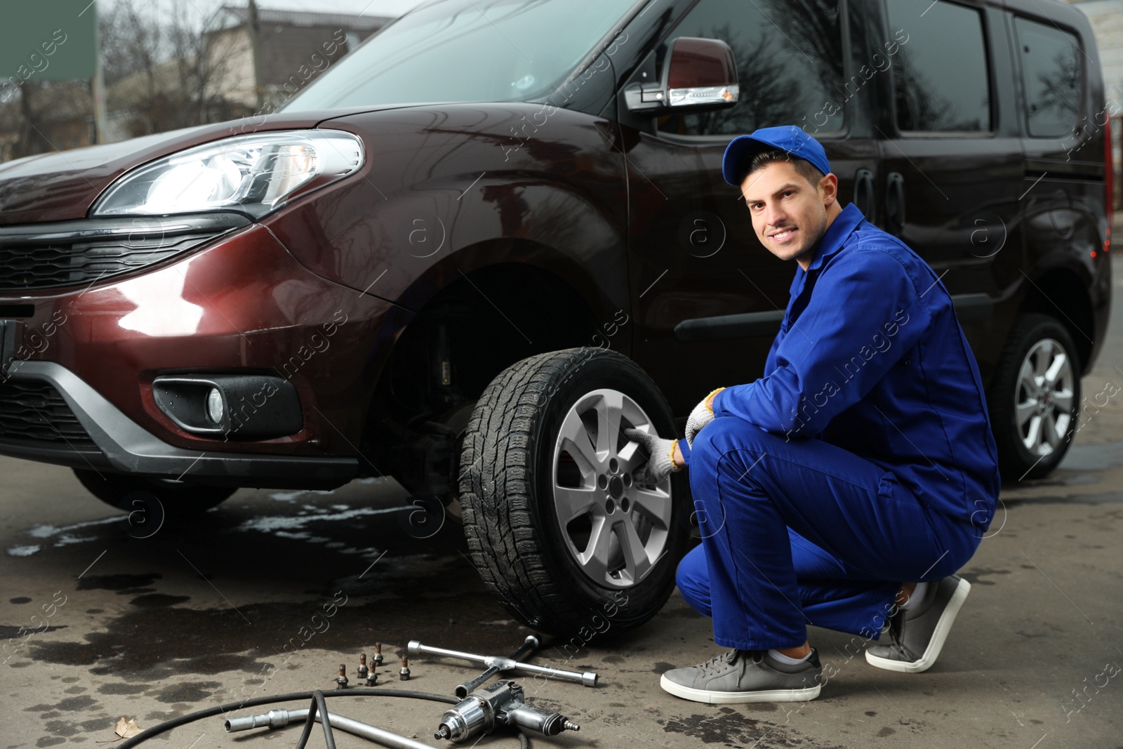 Photo of Worker changing car wheel at tire service