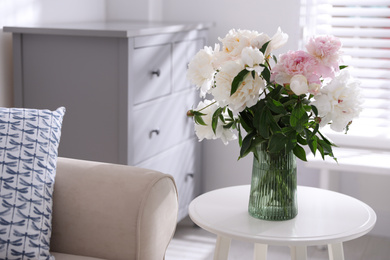 Photo of Bouquet of beautiful peony flowers on table indoors