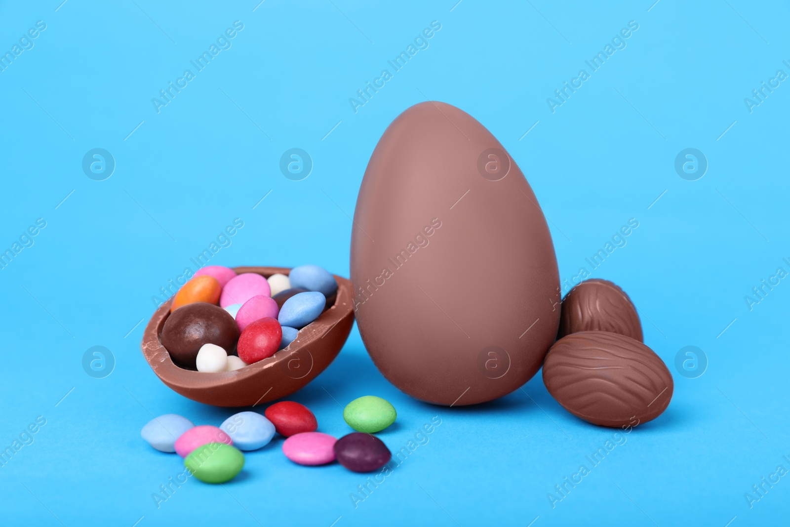 Delicious chocolate eggs and candies on light blue background, closeup Photo of Delicious chocolate eggs and candies on light blue background, closeup