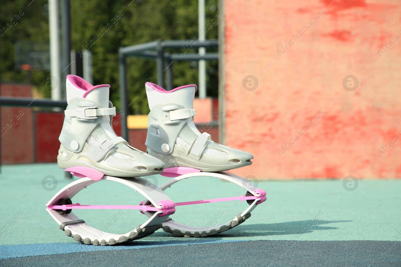 Photo of Stylish kangoo jumping boots in workout park. Space for text