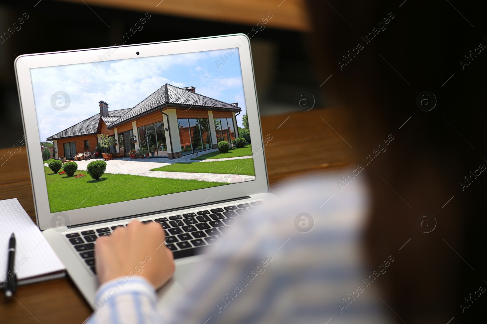 Image of Woman choosing new house online using laptop or real estate agent working at table, closeup