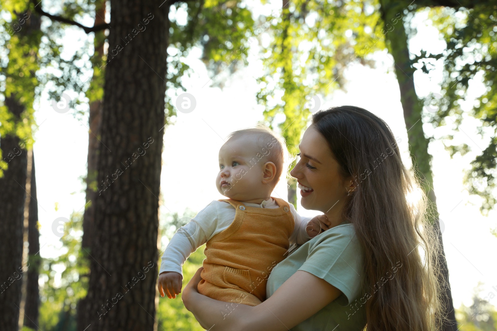 Photo of Beautiful mother with her cute daughter spending time together in park on summer day, space for text