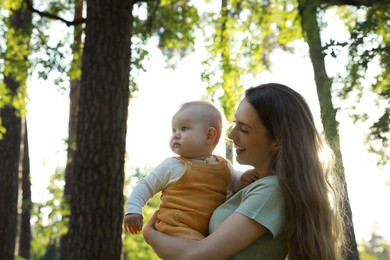 Photo of Beautiful mother with her cute daughter spending time together in park on summer day, space for text