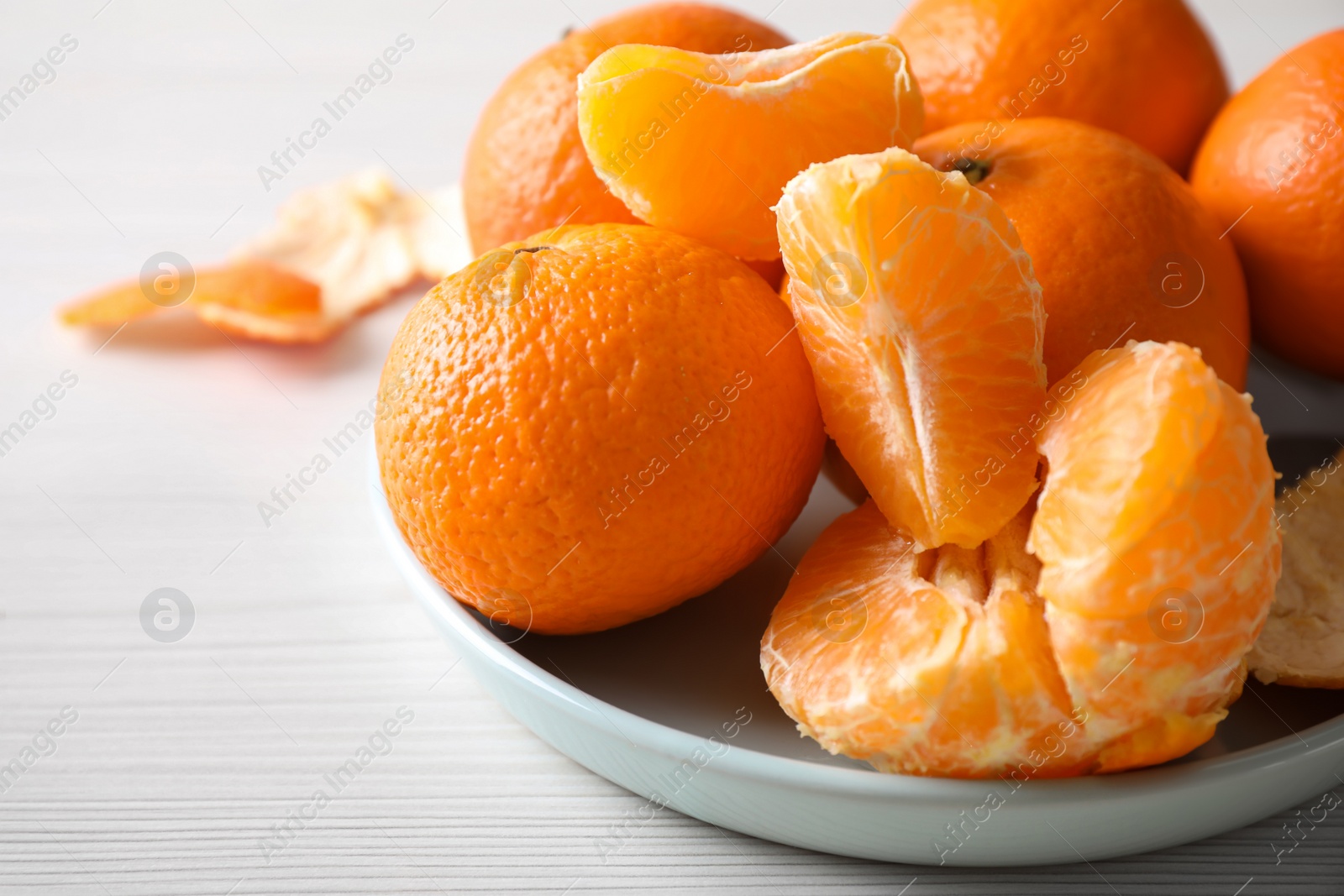 Photo of Delicious fresh ripe tangerines on white table, closeup