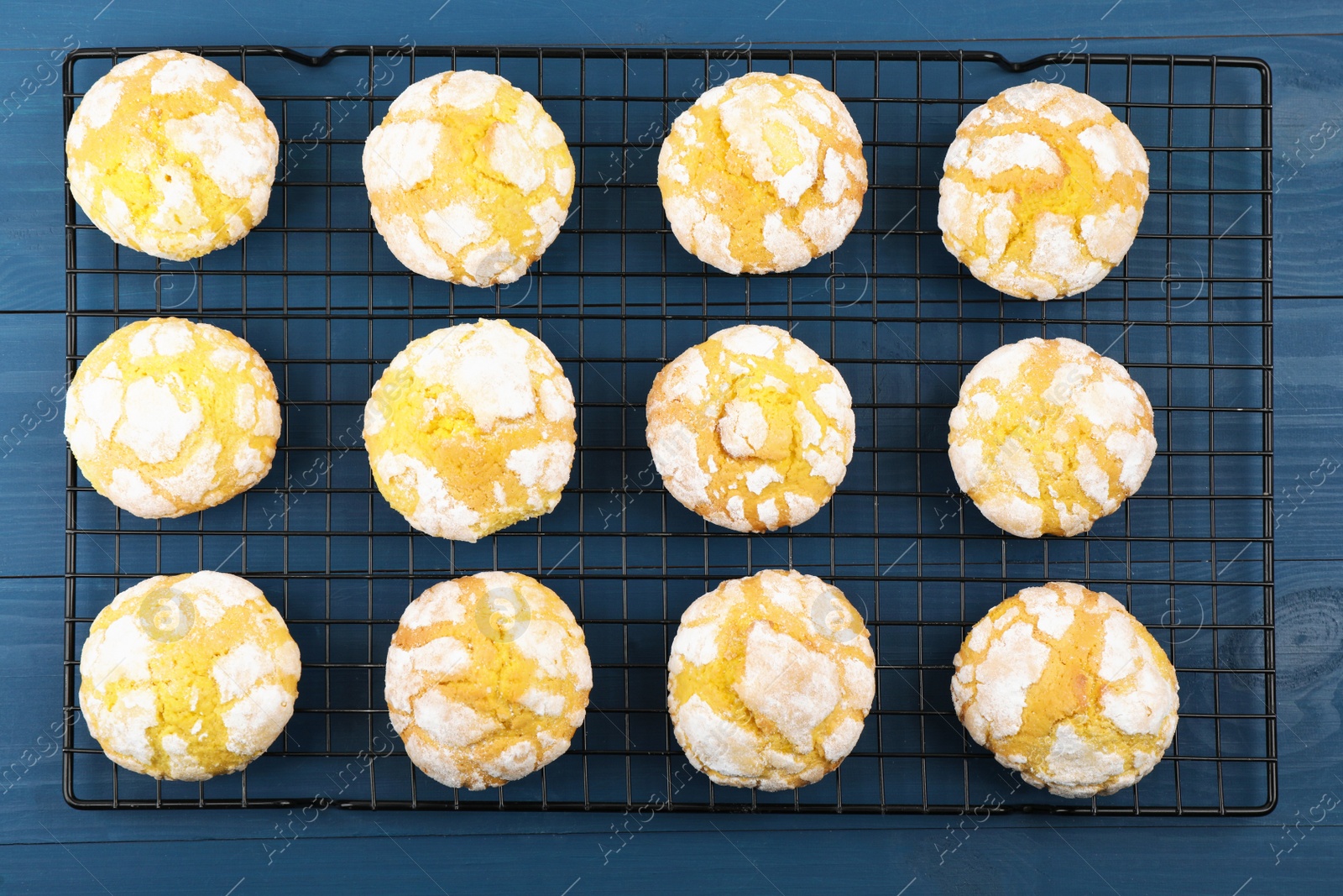 Photo of Tasty homemade lemon cookies on blue wooden table, top view