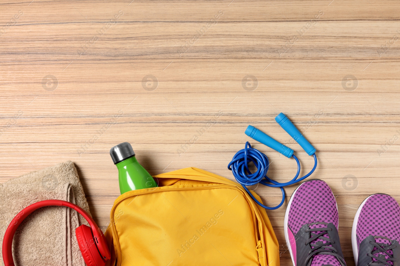 Photo of Flat lay composition with backpack and different sports equipment on wooden surface. Space for text