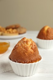 Photo of Delicious sweet muffin on white wooden table