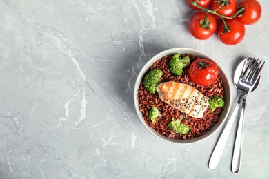 Photo of Flat lay composition with delicious cooked brown rice on table. Space for text