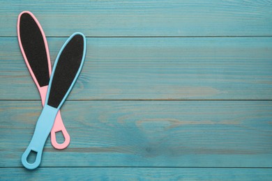 Colorful foot files on light blue wooden table, flat lay with space for text. Pedicure tools