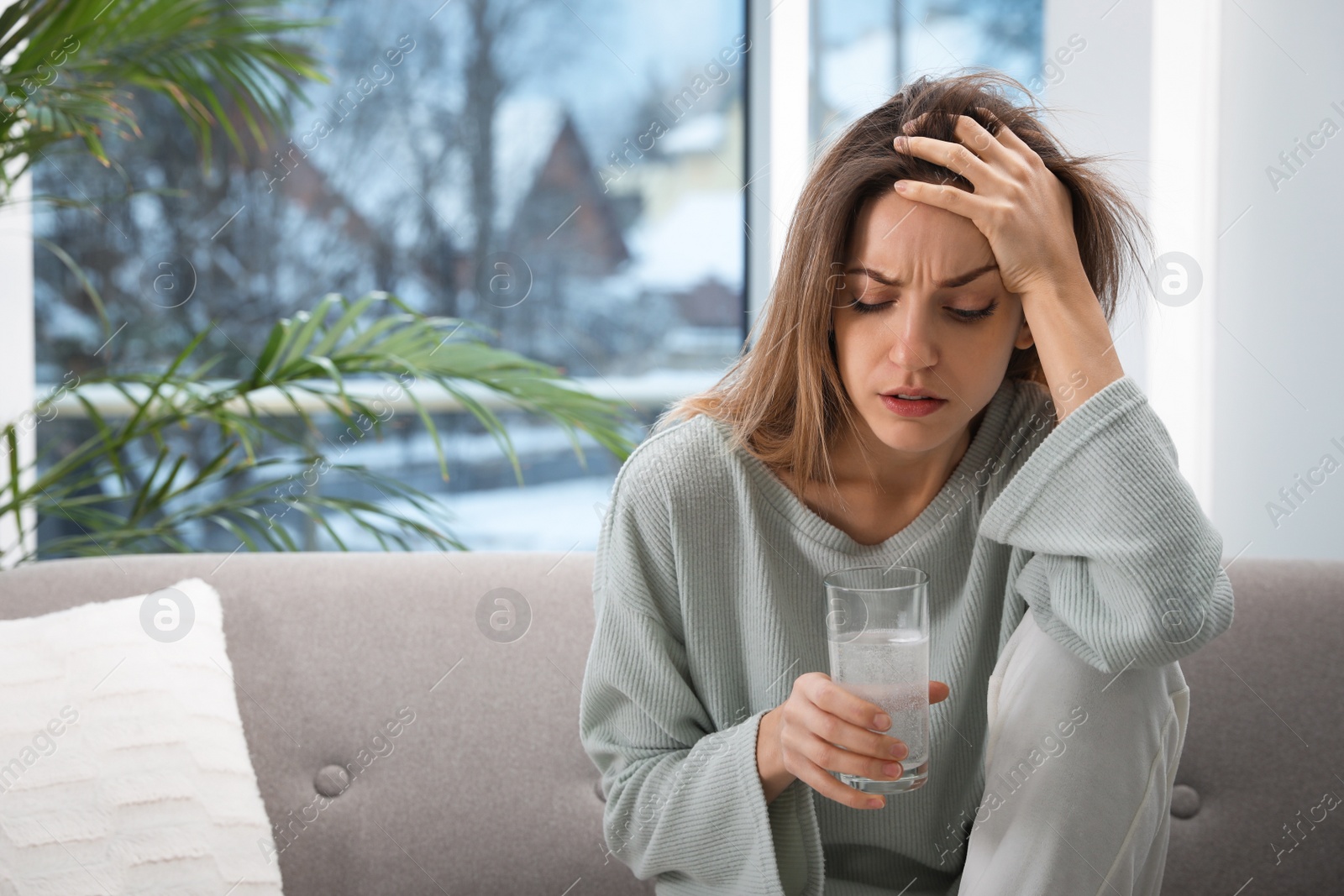 Photo of Woman holding glass of medicine for hangover at home