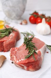 Photo of Fresh raw meat with rosemary on parchment paper, closeup