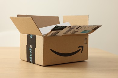 Photo of Leiden, Netherlands - October 6, 2023: New iPhone 15 Pro Max in cardboard box on wooden table. Amazon delivery