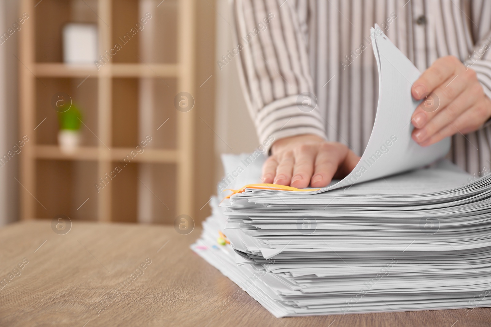 Photo of Woman stacking documents at wooden table indoors, closeup. Space for text