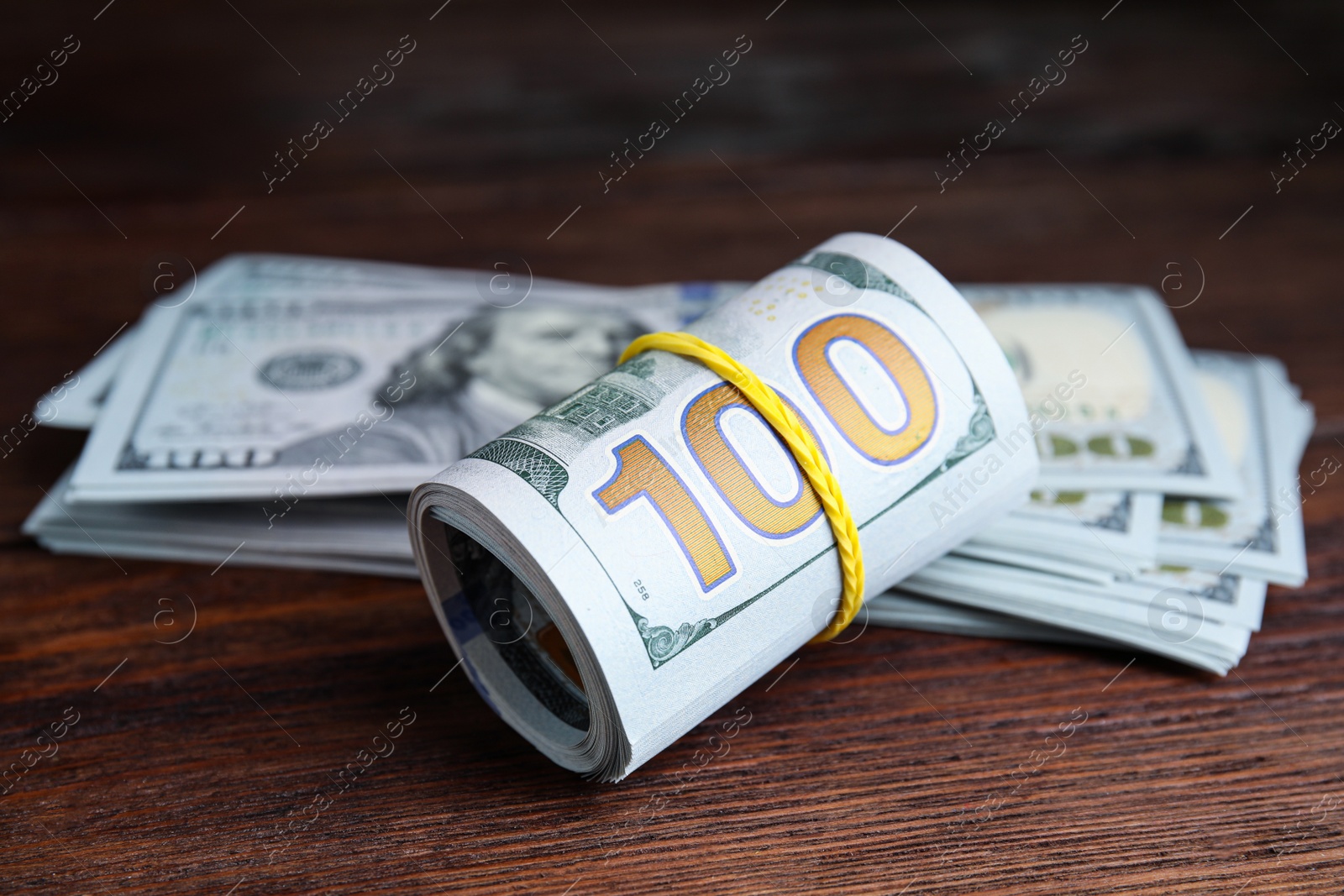 Photo of Many dollar banknotes on wooden table, closeup