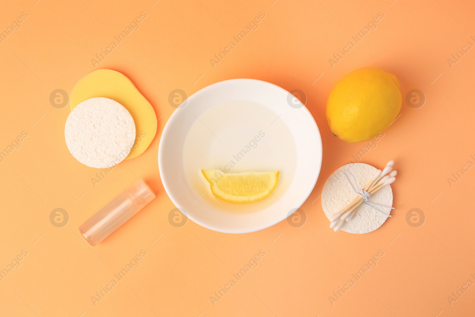 Photo of Lemon face cleanser. Fresh citrus fruits and personal care products on pale orange background, flat lay