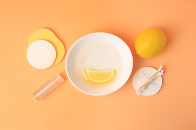 Lemon face cleanser. Fresh citrus fruits and personal care products on pale orange background, flat lay