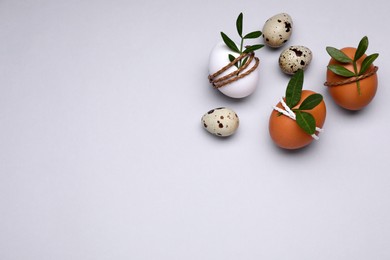 Beautifully decorated Easter eggs on light grey background, flat lay. Space for text