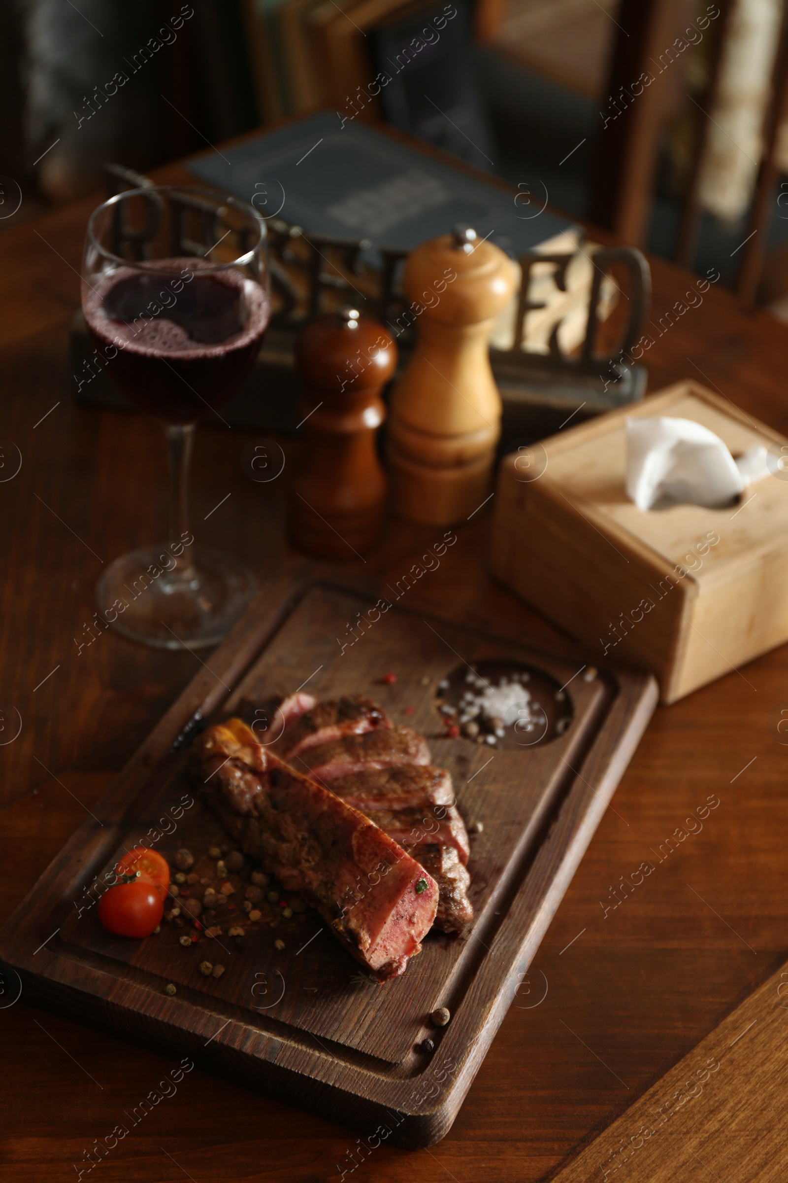 Photo of Tasty roasted meat served on wooden table in restaurant. Cooking food