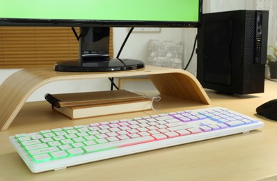 Modern RGB keyboard on wooden table indoors