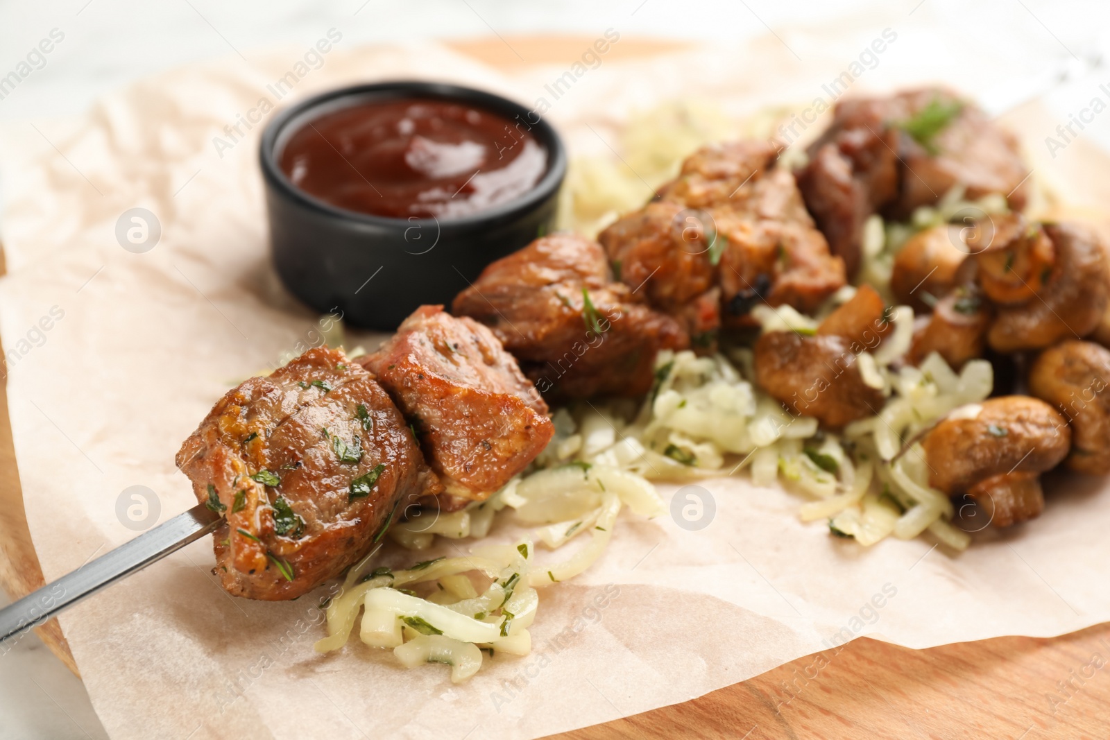 Photo of Metal skewer with delicious meat, vegetables and ketchup on wooden board, closeup