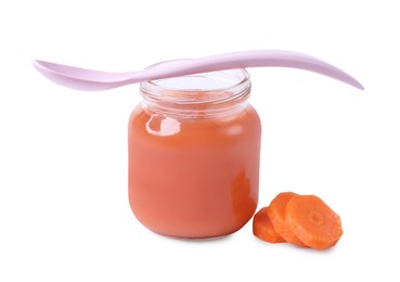 Jar of healthy baby food, carrot slices and spoon on white background