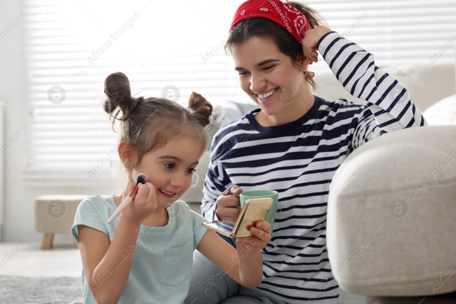 Photo of Young mother and her daughter spending time together at home