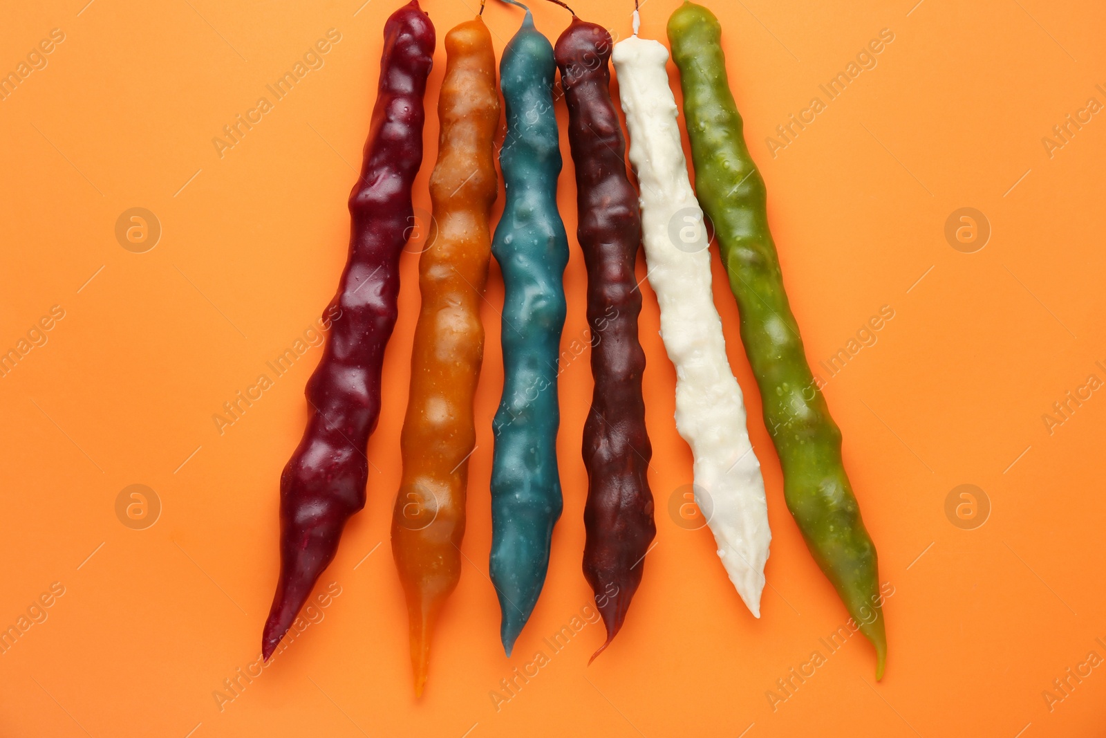 Photo of Many different delicious churchkhelas on orange background, flat lay