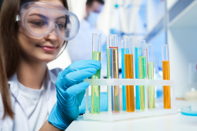 Scientist taking test tube from rack indoors. Laboratory analysis