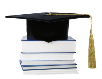 Graduation hat with gold tassel and stack of books isolated on white