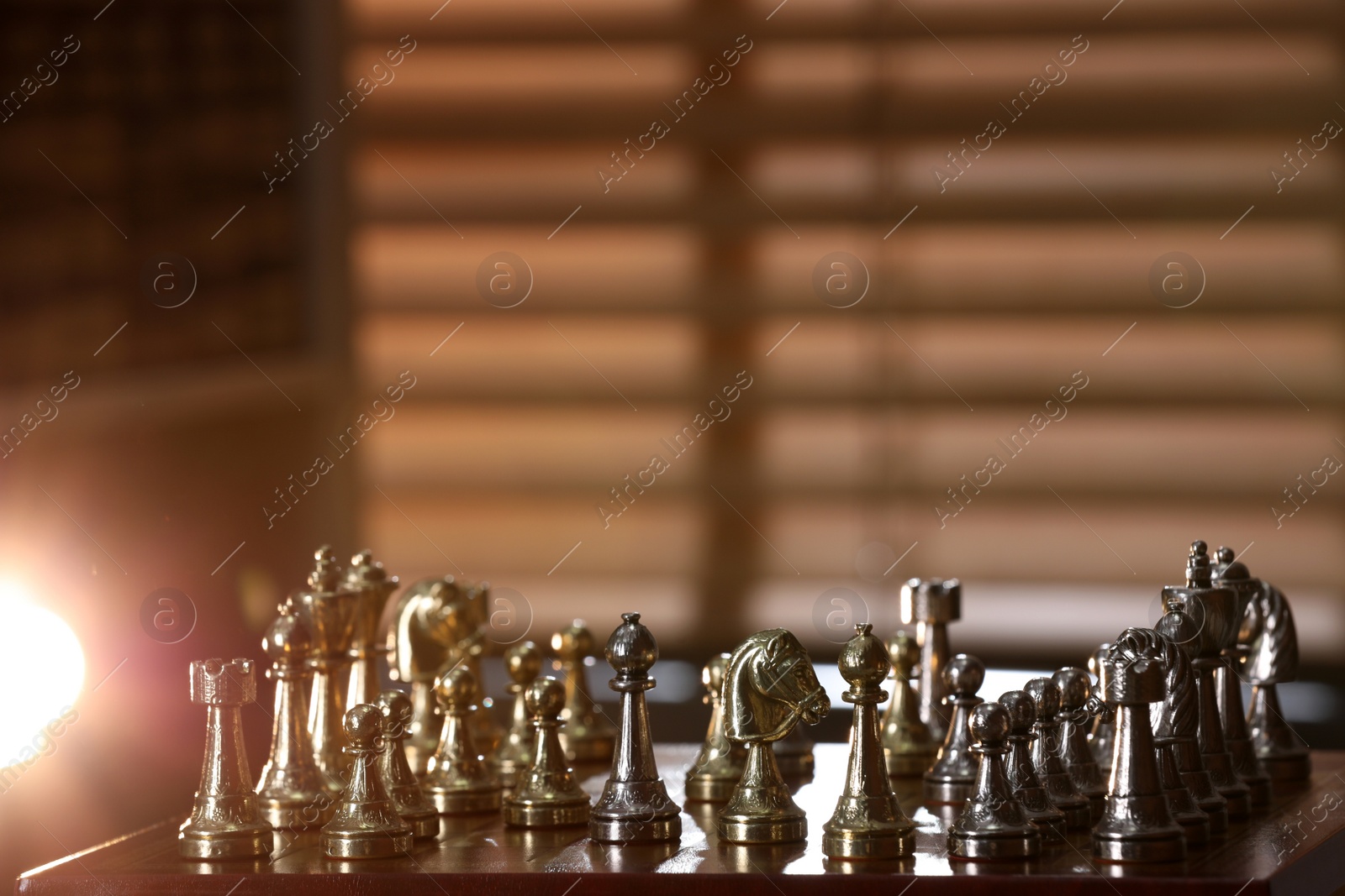 Photo of Chessboard with game pieces near window indoors, space for text