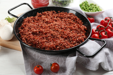 Photo of Tasty brown rice on white wooden table