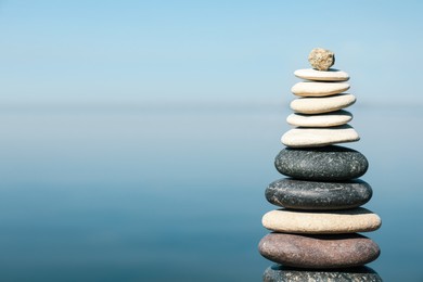 Stack of stones near sea, space for text. Harmony and balance concept