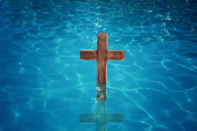 Image of Wooden cross in water for religious ritual known as baptism