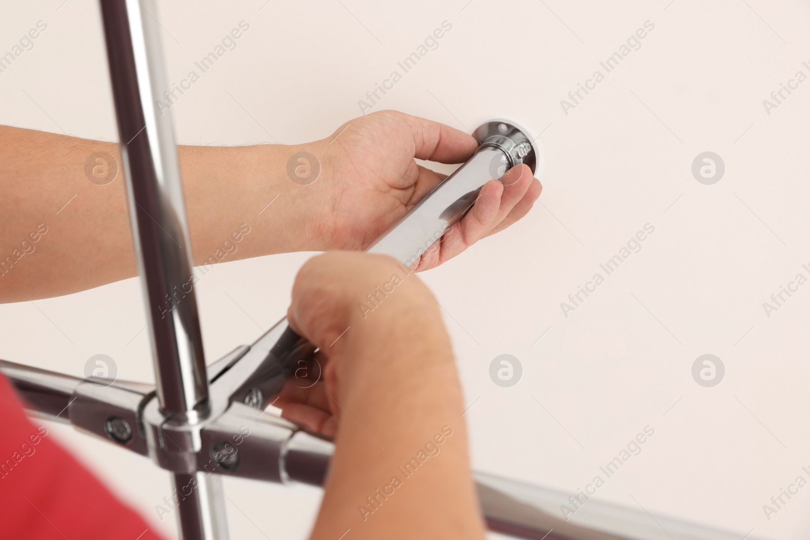 Photo of Worker installing new metal pipes indoors, closeup