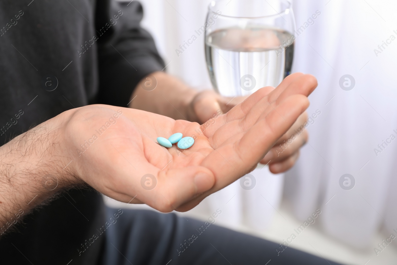 Photo of Young man taking pills, closeup