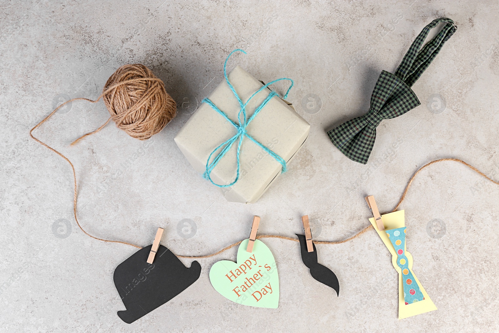 Photo of Composition with gift box and bow tie on grey background. Father's day celebration