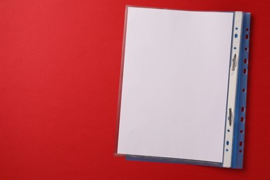 Photo of File folder with punched pockets on red background, top view. Space for text