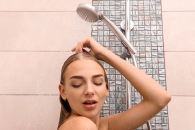 Photo of Beautiful young woman taking shower at home