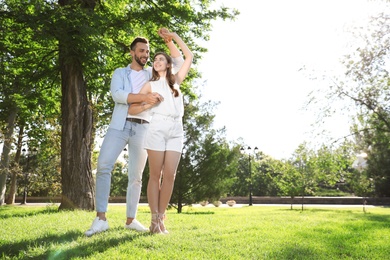 Photo of Lovely young couple dancing together in park on sunny day