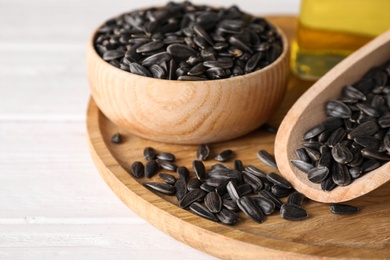 Photo of Sunflower seeds and oil on white table