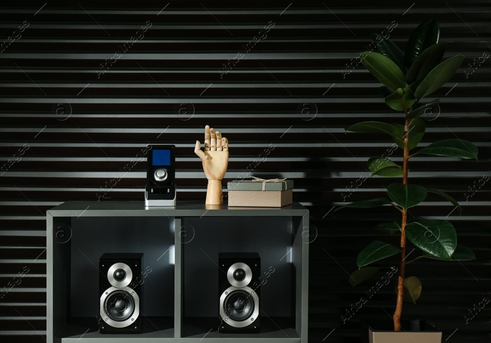 Photo of Modern audio speakers and remote on shelving indoors